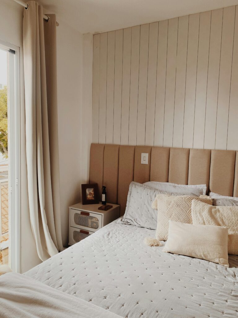 Stylish beige-toned bedroom with shiplap walls and modern decor.